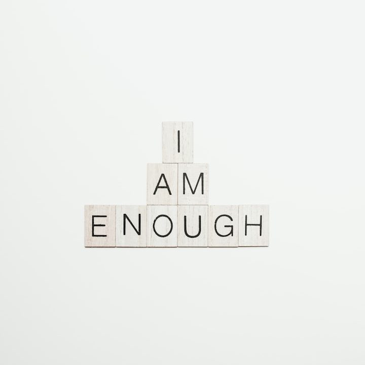 Weißer Hintergrund mit den Wörtern „I AM ENOUGH“ aus Buchstaben.